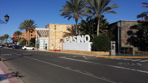 an empty street in front of a building with palm trees at Villa con Piscina ,Vista Mar y campo de golf in Caleta De Fuste