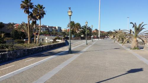 a sidewalk with palm trees and a street light at Villa con Piscina ,Vista Mar y campo de golf in Caleta De Fuste
