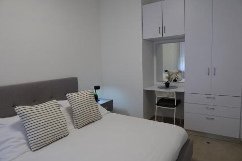 a bedroom with a bed with two pillows and a desk at צימר פסטורלי בהגושרים in HaGoshrim