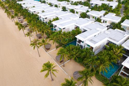 an aerial view of a resort on a beach with palm trees at Angsana Ho Tram in Ho Tram