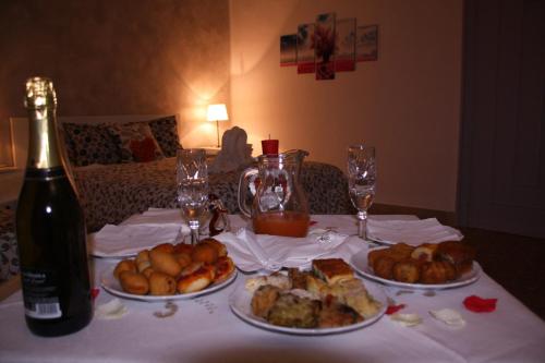 a table with three plates of food and a bottle of wine at Central House in Reggio di Calabria