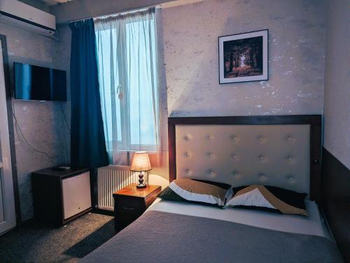 a bedroom with a bed and a window at The Rogashome in Tbilisi City
