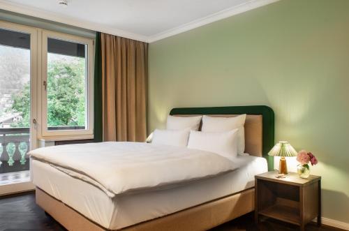 a bedroom with a large bed and a window at Bartl Apartments in Rottach-Egern