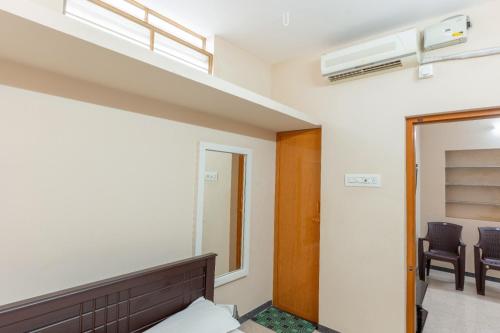 a room with a bed and a window and a mirror at KUKAL CASTLE in Tiruppūr