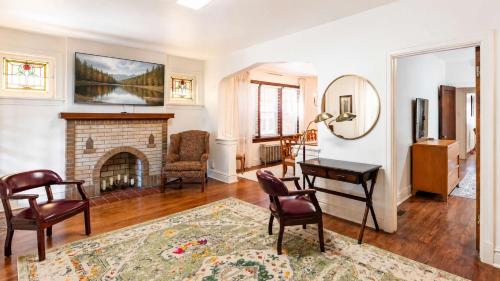 a living room with a fireplace and a table and chairs at Historic 2BR with Deck Games & Garage in Saint Louis