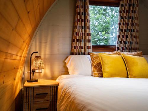a bedroom with a bed with a lamp and a window at Revive Wellness Pods in Rostrevor