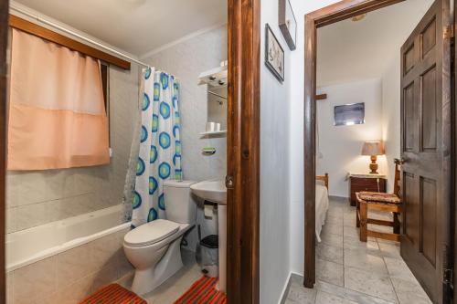 a bathroom with a toilet and a sink and a shower at Villa Hara Kiotari in Gennadi