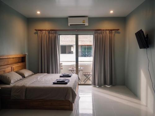 a bedroom with a bed and a window at Orient Hotel in Jomtien Beach