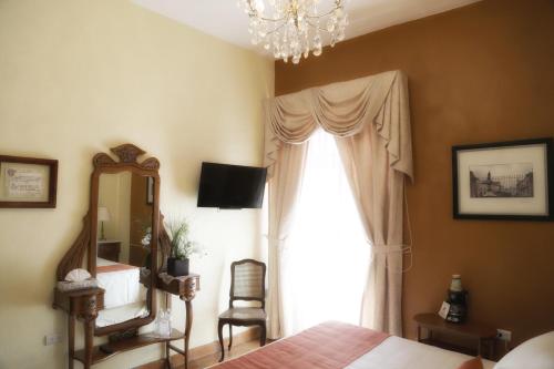 a bedroom with a bed and a window with a chandelier at El Meson de los Poetas in Guanajuato
