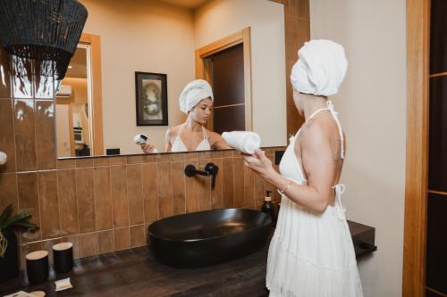 a woman with a towel on her head standing in front of a mirror at Notos Home in Bitonto