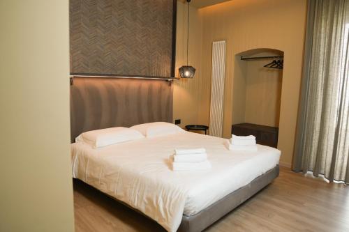 a bedroom with a bed with white sheets and pillows at Notos Home in Bitonto