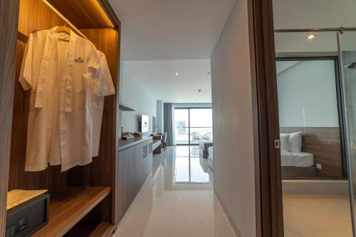 a bathroom with a robe hanging on a wall at Long Thuan Hotel & Resort in Phan Rang–Tháp Chàm