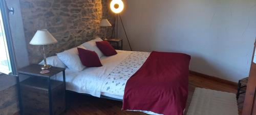 a bedroom with a bed and a lamp on a table at Chambres d'hôtes Sous L'Olivier in Trausse