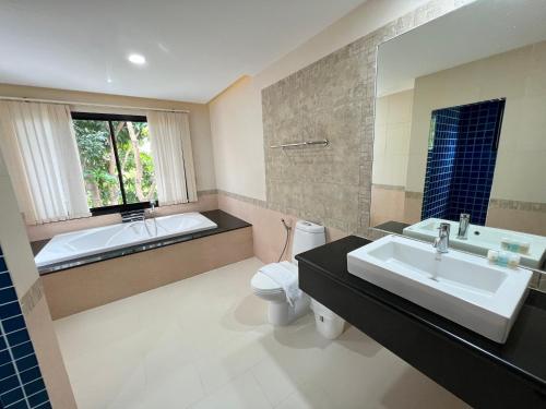 a bathroom with a tub and a toilet and a sink at Panya Samui in Choeng Mon Beach