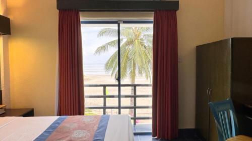 a bedroom with a window with a view of the beach at Microtel by Wyndham Puerto Princesa in Puerto Princesa City