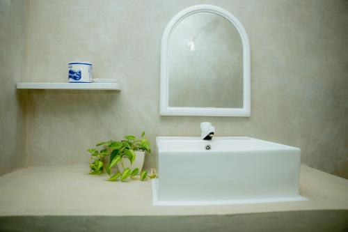 a bathroom with a white sink and a mirror at Beach Lovers Tiny House in Nilaveli