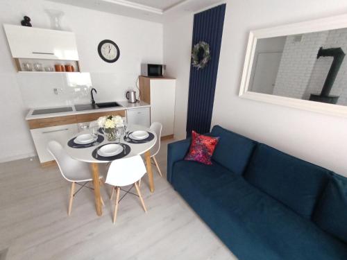 a living room with a blue couch and a table at VILLA KINGA ROWy in Rowy