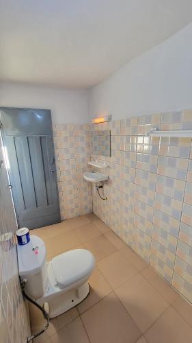 a bathroom with a toilet and a sink at ELIEL Guesthouse in Parakou