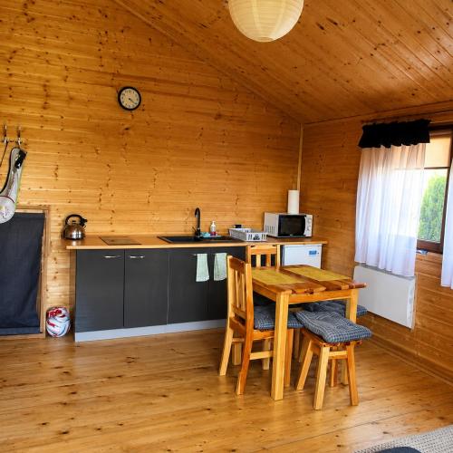 a kitchen with a table and chairs in a cabin at Witówka Bieliny in Bieliny