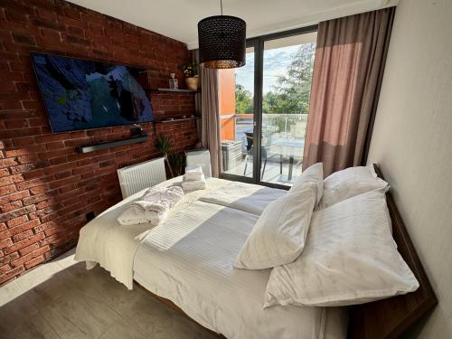 a bed in a room with a brick wall at Sea Power Studio Loft in Jastrzębia Góra