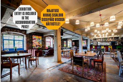 a restaurant with tables and chairs and signs at Viscosa Hotell in Kõrgessaare