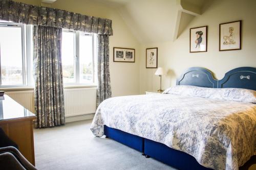 a bedroom with a blue bed and a window at Leander Club in Henley on Thames
