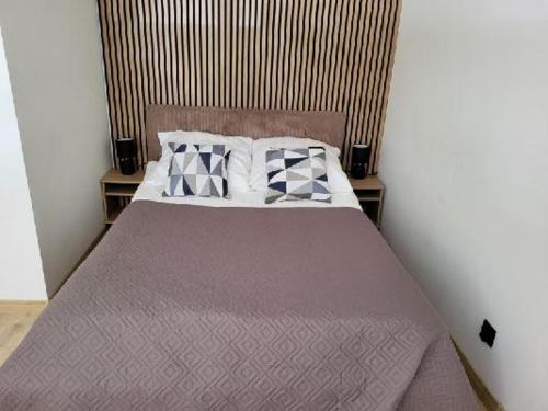 a bedroom with a bed with a wooden headboard and pillows at apartament in Tomaszów Mazowiecki