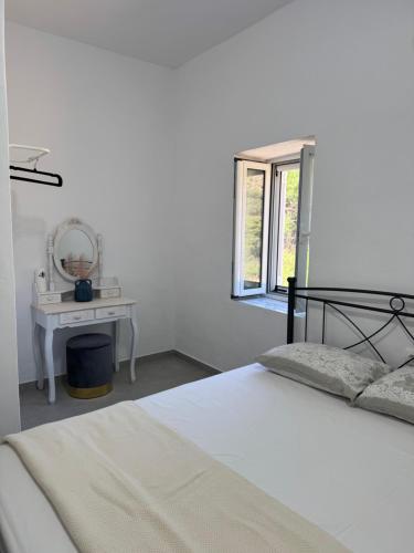a bedroom with a bed and a table with a mirror at Sykano Espace, Skyros Island in Skiros