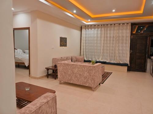 a living room with a couch and a table at Sunset View Luxury Apartments in Nathia Gali