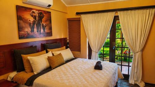 a bedroom with a bed and a painting on the wall at Kimba Lodge and Tours in Phalaborwa