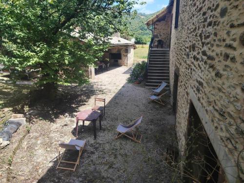 a group of chairs and tables next to a building at Lo Castel de Lasmaries in Saint-Parthem