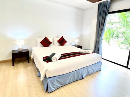 a bedroom with a large bed and a large window at Panya Samui in Choeng Mon Beach