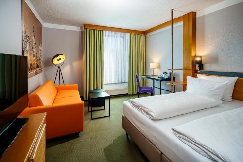 a hotel room with a bed and a chair at Best Western Parkhotel Brehna-Halle in Brehna