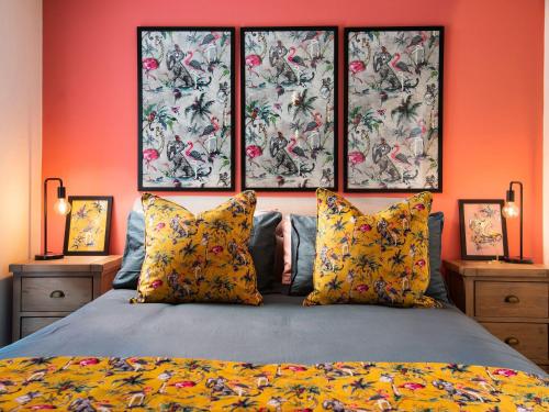 a bedroom with orange walls and a bed with pillows at Summerset Lodge in Bamburgh