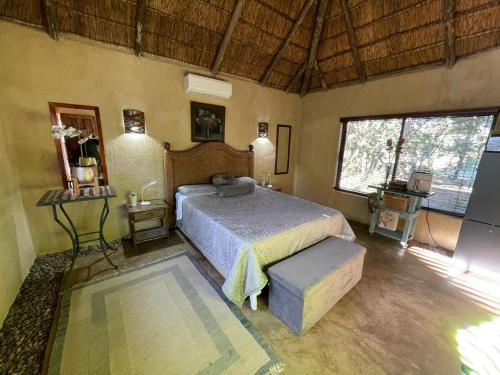 a bedroom with a bed and a large window at Kulilo Lodge in Thabazimbi