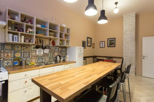 a kitchen with a wooden table and some chairs at Falling Lakes Hostel in Korenica