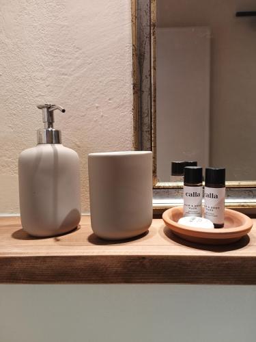 a bathroom counter with a bottle of soap and a cup at Domus Mazzoni in Capannori