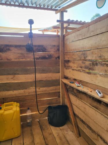 a shower with a hose attached to a wooden fence at Ruhondo Campsite View in Muhororo