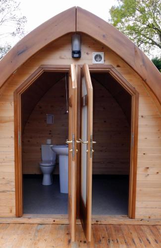 a large wooden shed with a toilet in it at Revive Wellness Pods in Rostrevor