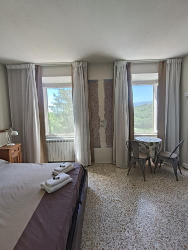 a bedroom with a bed and a table and windows at Domus Mazzoni in Capannori