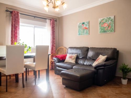 a living room with a leather couch and a table at Comfortable Apartment Ayamonte Garden in Ayamonte