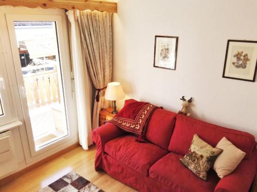 a red couch in a living room with a window at Spacious Apartment in Lens with Mountain View in Lens