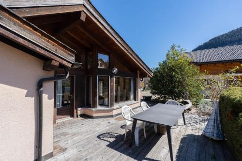 a wooden deck with a table and chairs on it at Malgré tout 2 in Salvan