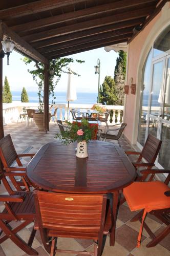 a table and chairs on a patio with a view of the ocean at Niki Sunrise Apartments in Gastourion
