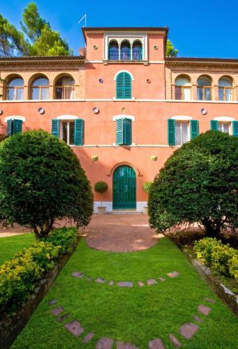 an orange building with a green door and bushes at Comfortable Apartment in Fabriano, 35 m² with Shared Pool in Fabriano