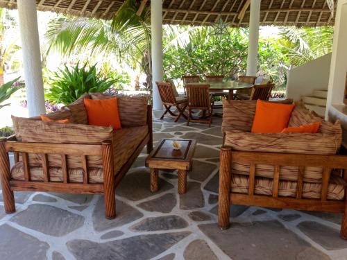 two sets of chairs and a table on a patio at Spacious accessible house in Watamu, shared pool in Watamu