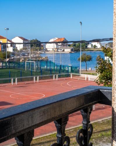 a tennis court next to a body of water at Charming Apartment in El Grove, Sea View in O Grove