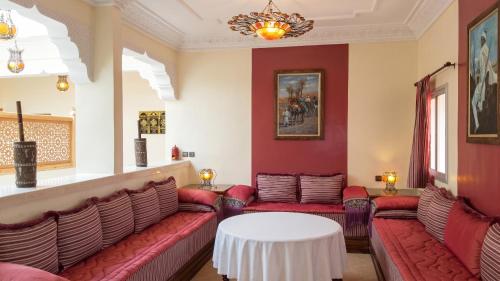 a waiting room with red couches and a white table at Charming Villa in Tou Ganaou with Private Pool in Ti nʼ Saïd
