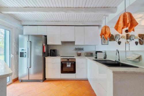 a kitchen with white cabinets and a stainless steel refrigerator at Quinta da Amora in Quinta do Anjo