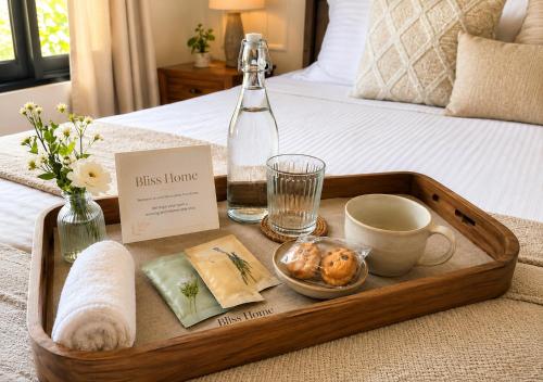 a tray with food and a bottle on a bed at Bliss Home in Harrow on the Hill
